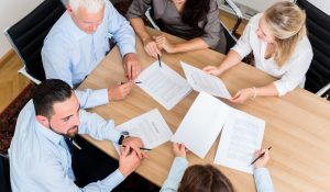 Lawyers,Having,Team,Meeting,In,Law,Firm,Reading,Documents,And